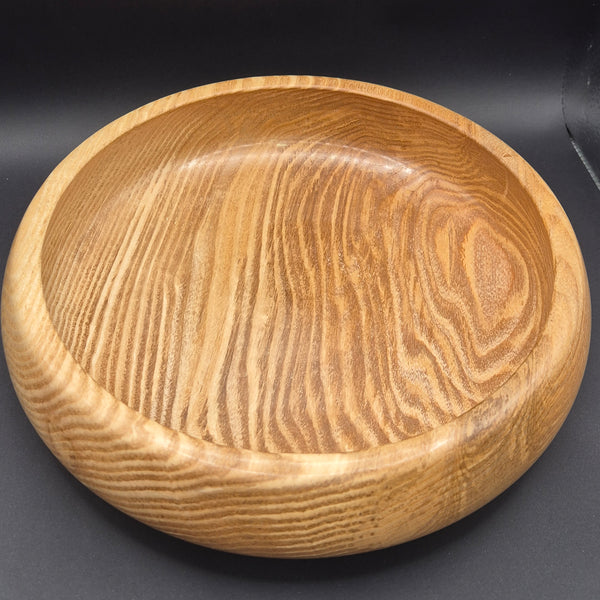 Hand-turned Donegal olive ash wood bowl front view on wooden surface